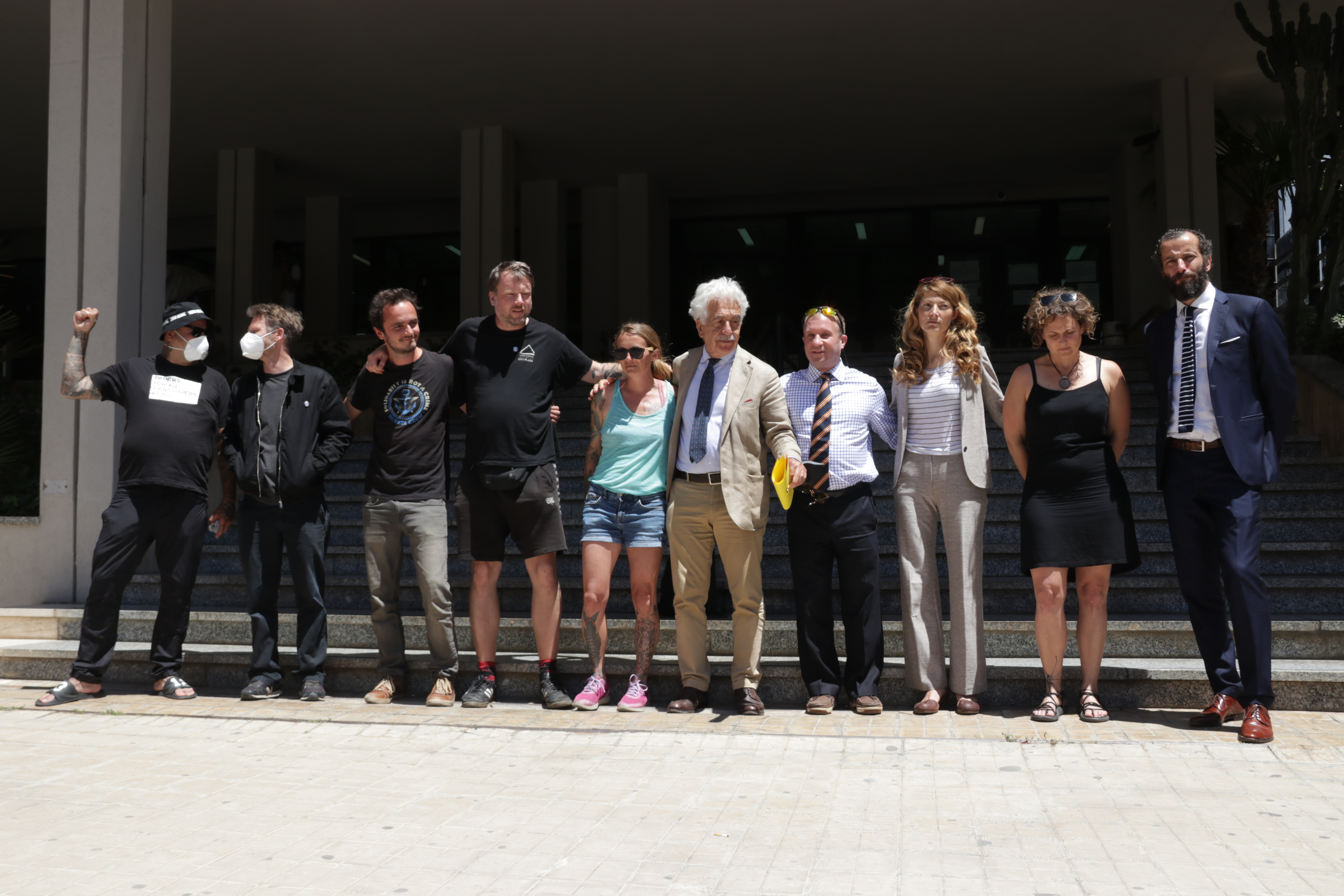 Die vier Angeklagten der Iuventa-Crew mit Anwält*innen und weiteren Crewmitgliedern vorm Gericht in Trapani